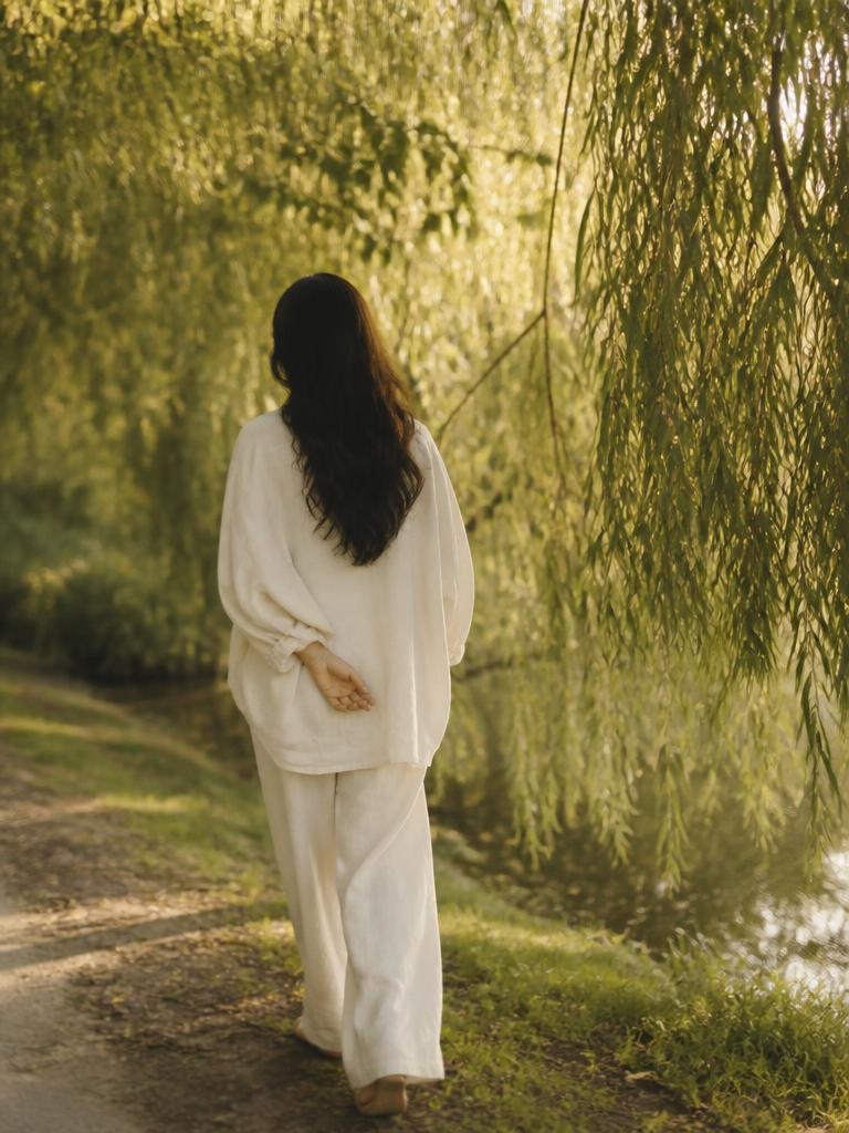 Our Vision — a woman walking beneath willow branches toward warm light.